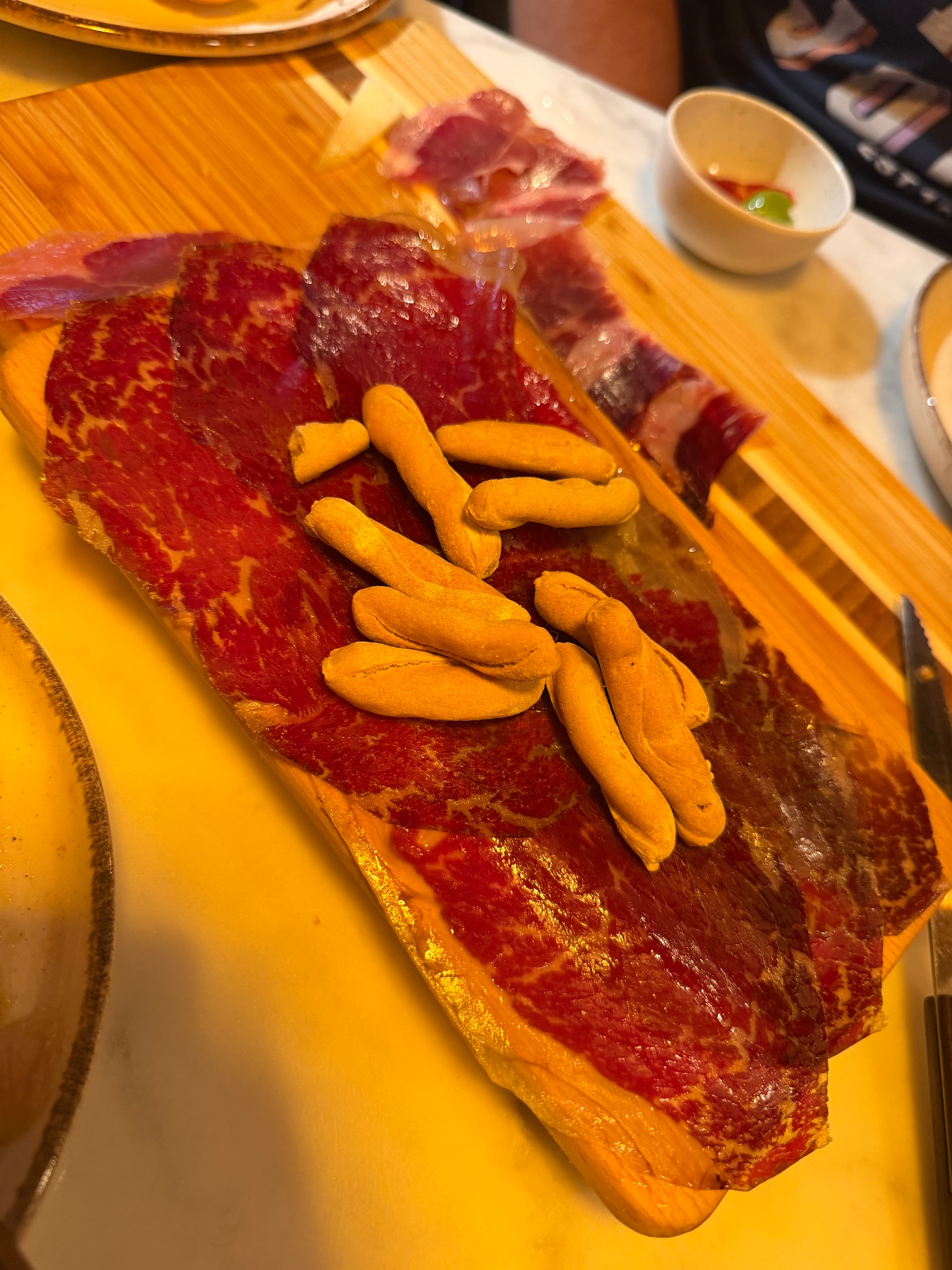 Dünn aufgeschnittener luftgetrockneter Schinken mit kleinen Brotstangen in Palma