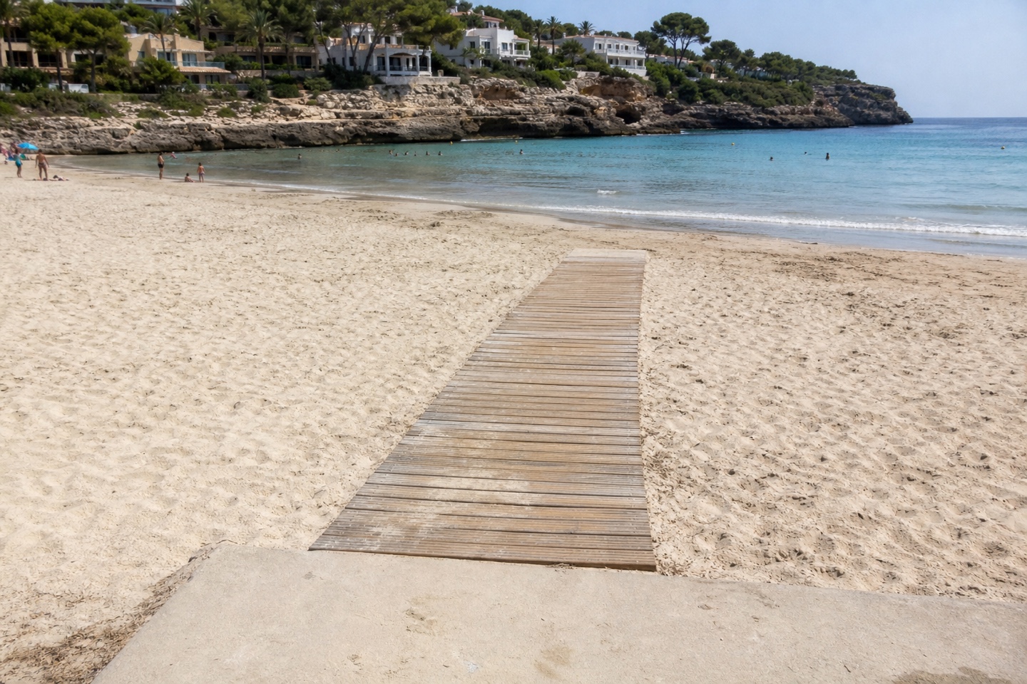 KI-generiertes Stimmungsbild eines plausiblen Holzstegs zum feuchten Sandbereich von Cala Mendia