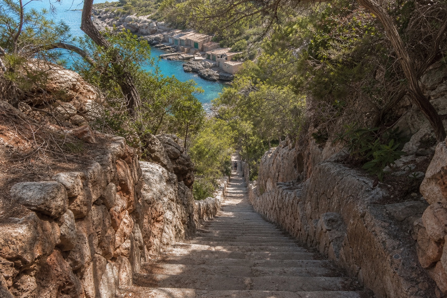 KI-generiertes Stimmungsbild der steilen Treppe hinunter zur Cala s’Almunia an Mallorcas Südostküste