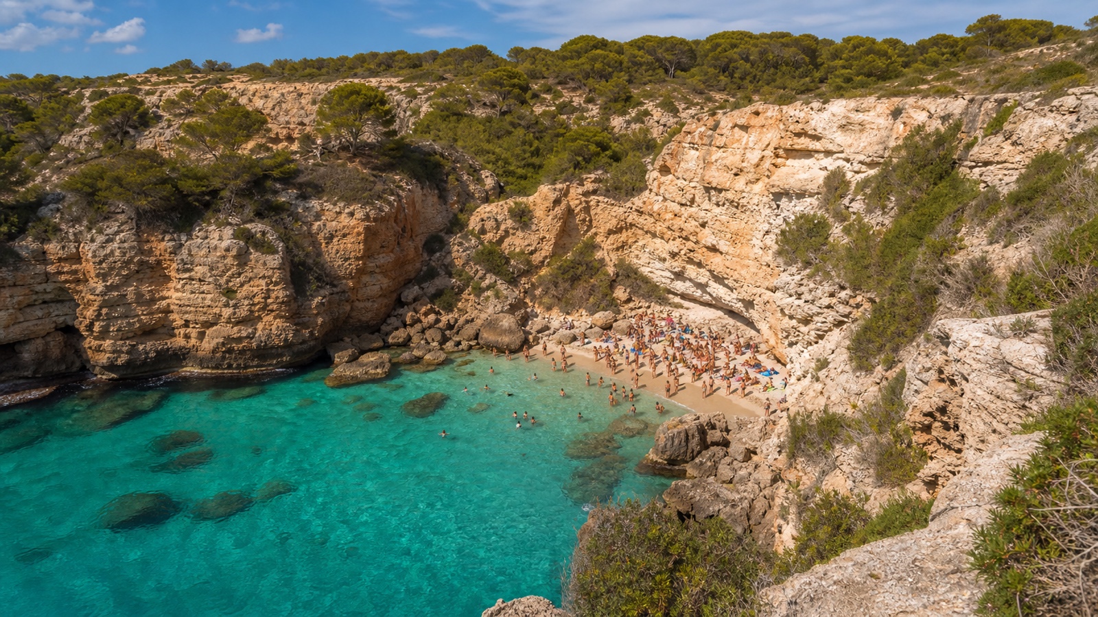 KI-generiertes Stimmungsbild der kleinen Felsbucht Caló des Moro mit türkisfarbenem Wasser und schmaler Sandfläche