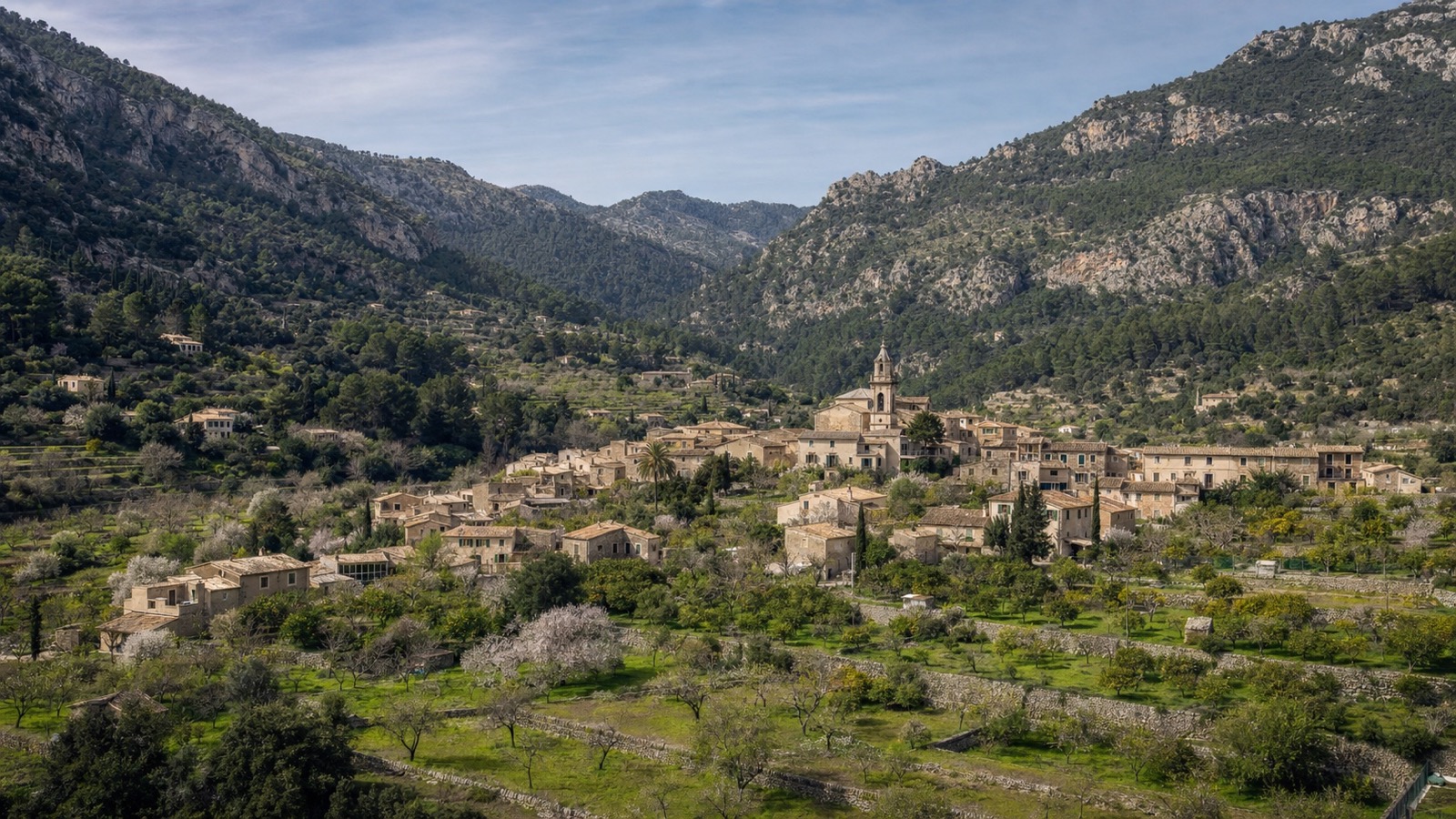 KI-generiertes Stimmungsbild von Puigpunyent im grünen Tramuntana-Tal mit Kirche, Obstgärten und Oliventerrassen